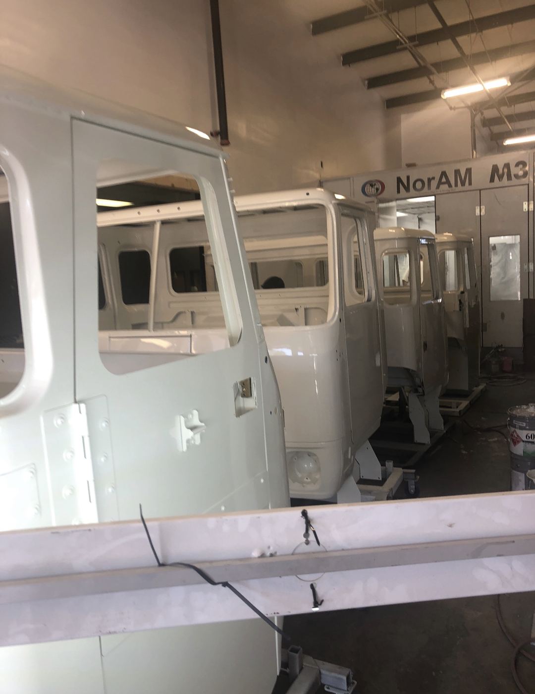 White cabs in the shop by the paint booth
